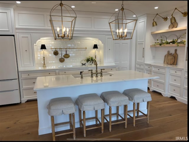 kitchen with white cabinetry, white fridge, a sink, and an inviting chandelier