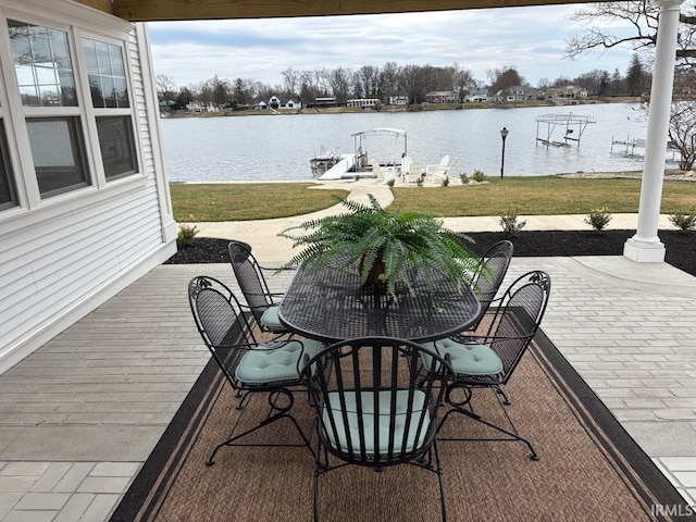 exterior space with a lawn, a water view, a patio, and outdoor dining space