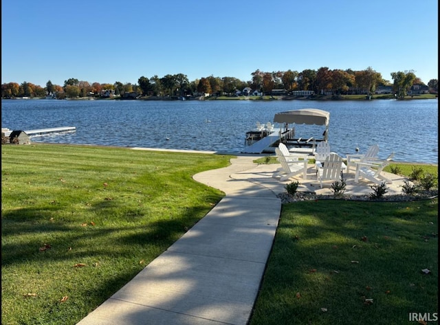 dock area with a lawn and a water view