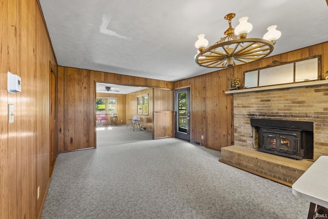 7990 S 150 E, Wolcottville, IN 46795 - unfurnished living room featuring wood walls, an inviting chandelier, carpet, visible vents, and a fireplace