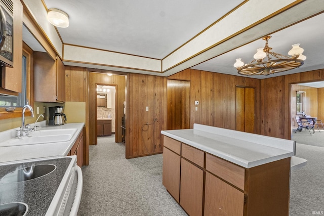 7990 S 150 E, Wolcottville, IN 46795 - kitchen with electric range, a sink, wooden walls, a notable chandelier, and brown cabinetry