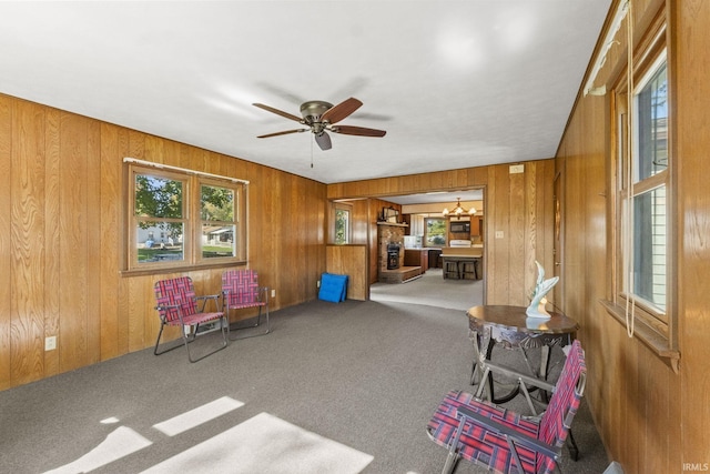 7990 S 150 E, Wolcottville, IN 46795 - sitting room featuring ceiling fan with notable chandelier, wood walls, and carpet flooring