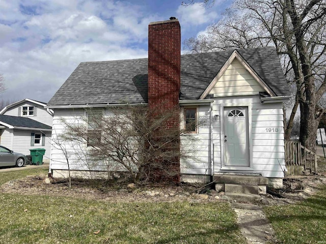 view of front of property with a chimney, entry steps, and a shingled roof