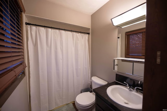 bathroom featuring a shower with curtain, toilet, and vanity