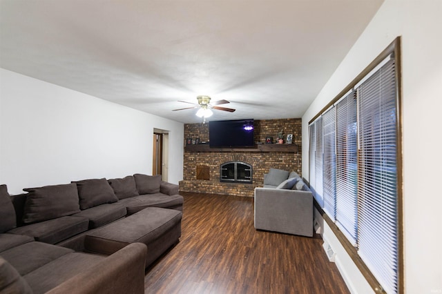 living area featuring a ceiling fan, a brick fireplace, and wood finished floors