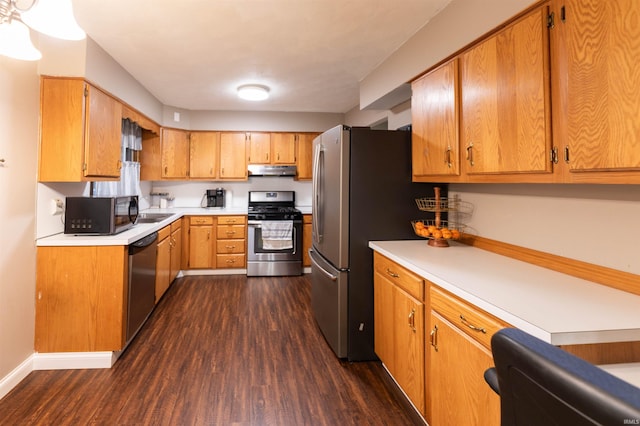 kitchen with light countertops, stainless steel appliances, dark wood-type flooring, under cabinet range hood, and brown cabinetry