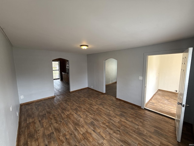 1116 Stanley Ave, Evansville, IN 47711 - empty room featuring dark wood finished floors, baseboards, and arched walkways