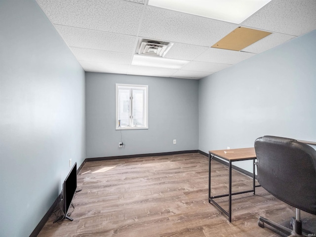office with baseboards, visible vents, a drop ceiling, and wood finished floors