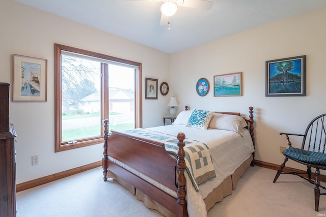 bedroom with a ceiling fan, baseboards, and light colored carpet
