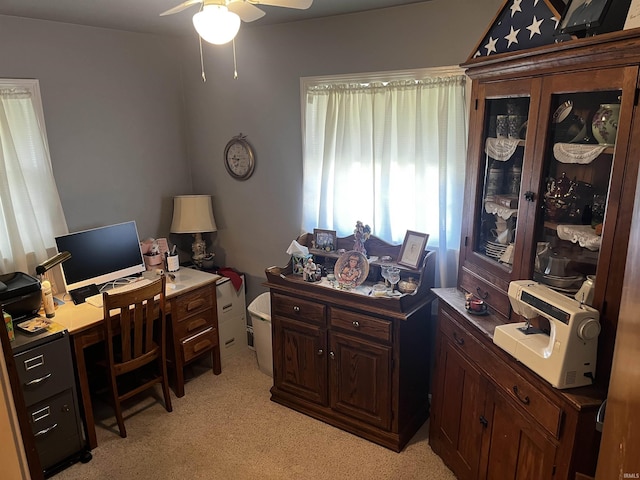 office space with a ceiling fan and light colored carpet