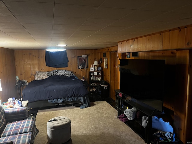 bedroom featuring carpet flooring and wooden walls