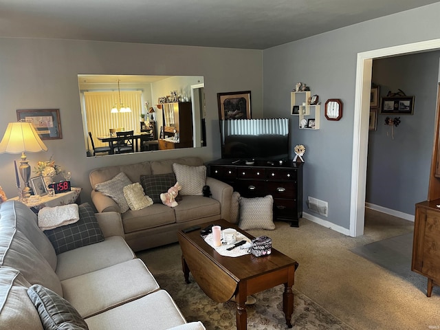 living area with carpet flooring, a notable chandelier, baseboards, and visible vents