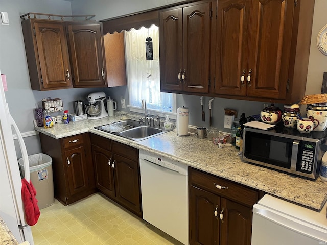 kitchen with a sink, light countertops, dishwasher, and stainless steel microwave
