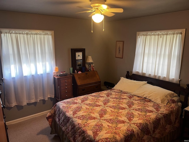 carpeted bedroom featuring a ceiling fan, baseboards, and multiple windows