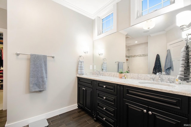 bathroom with ornamental molding, baseboards, a sink, tiled shower, and wood tiled floor
