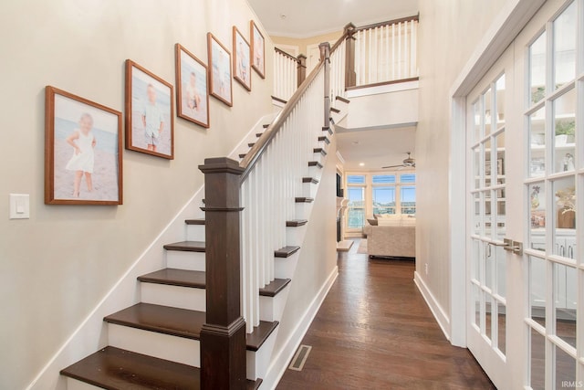 stairway featuring french doors, wood finished floors, baseboards, visible vents, and ceiling fan