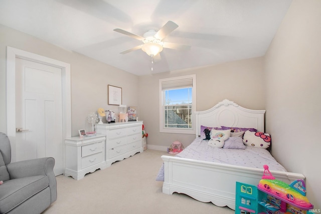 bedroom featuring baseboards, light colored carpet, and ceiling fan