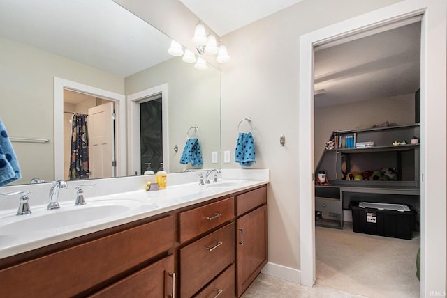 bathroom with double vanity, baseboards, and a sink