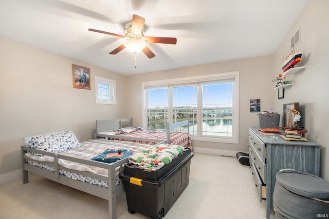 bedroom featuring visible vents, baseboards, light colored carpet, and ceiling fan