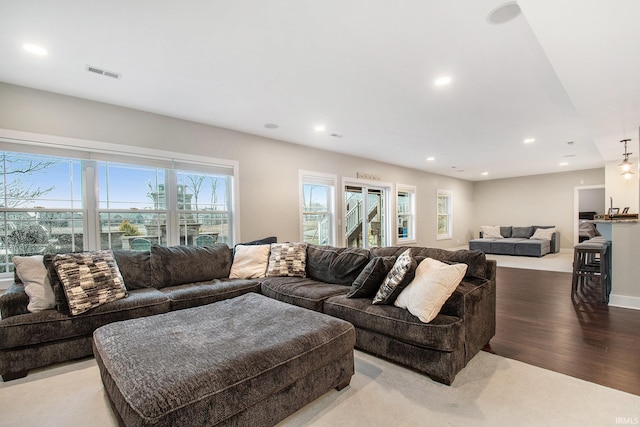 living room with visible vents, recessed lighting, and wood finished floors