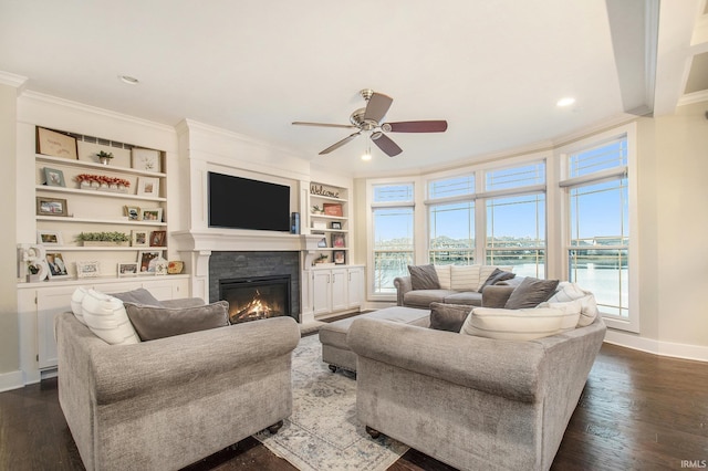 living area featuring dark wood finished floors, baseboards, crown molding, and ceiling fan
