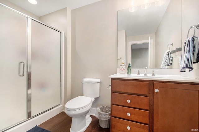 full bathroom with toilet, vanity, wood finished floors, and a shower stall