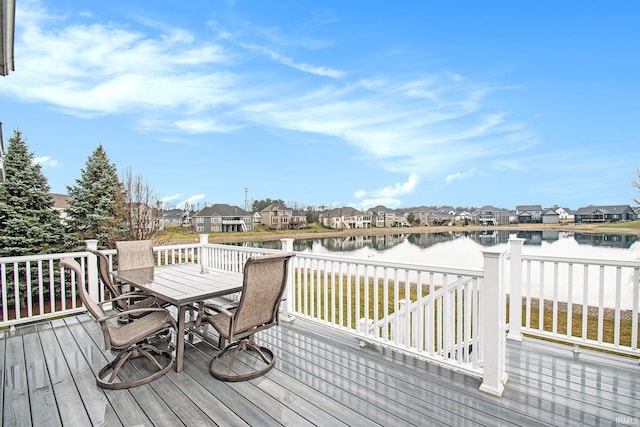 wooden deck with a residential view, outdoor dining area, and a water view
