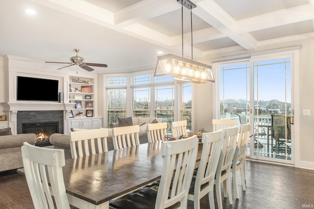 dining room featuring a stone fireplace, beamed ceiling, crown molding, and dark wood finished floors