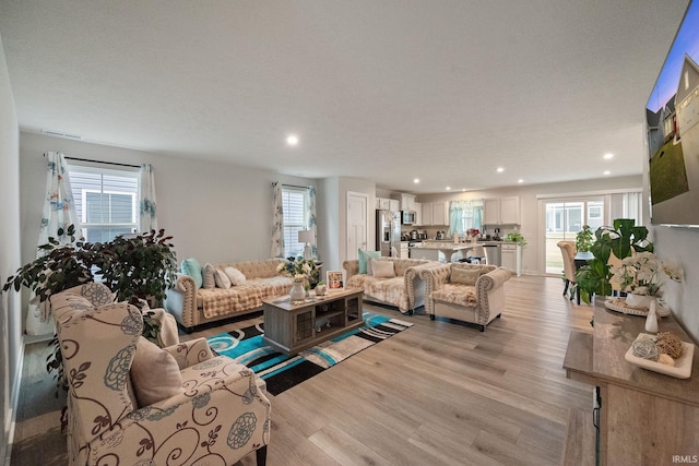 2751 Sand Hollow Dr, Lebanon, IN 46052 - living room with a textured ceiling, a healthy amount of sunlight, recessed lighting, and light wood-type flooring