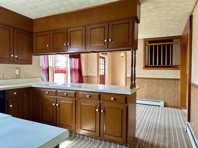 kitchen with a baseboard heating unit, light countertops, and wainscoting