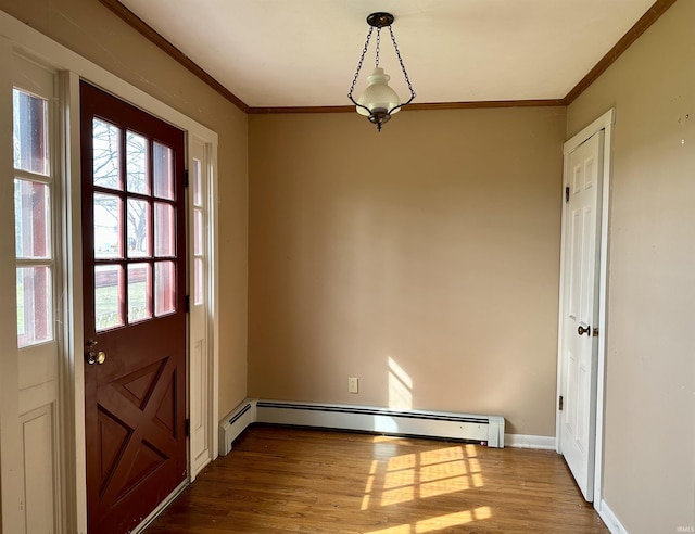 interior space with baseboard heating, crown molding, wood finished floors, and a healthy amount of sunlight
