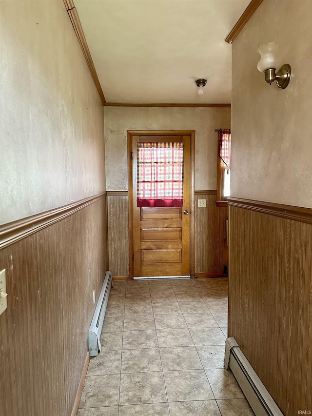 doorway featuring wainscoting, wood walls, a baseboard radiator, and crown molding