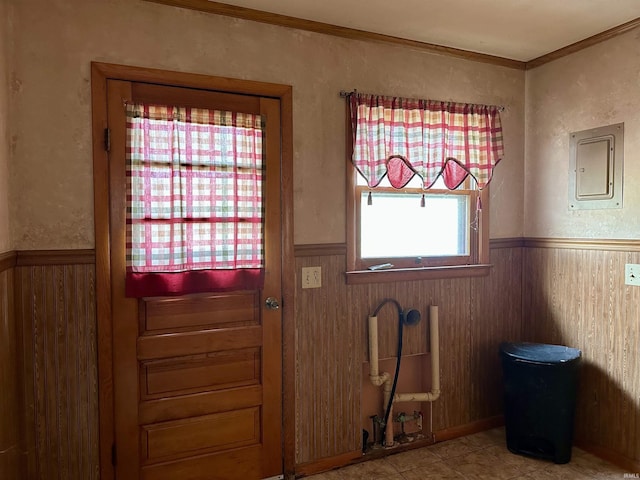 doorway to outside featuring radiator heating unit, wood walls, electric panel, crown molding, and wainscoting