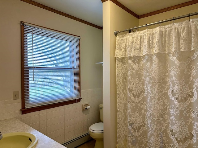 bathroom with plenty of natural light, toilet, a baseboard heating unit, tile walls, and crown molding
