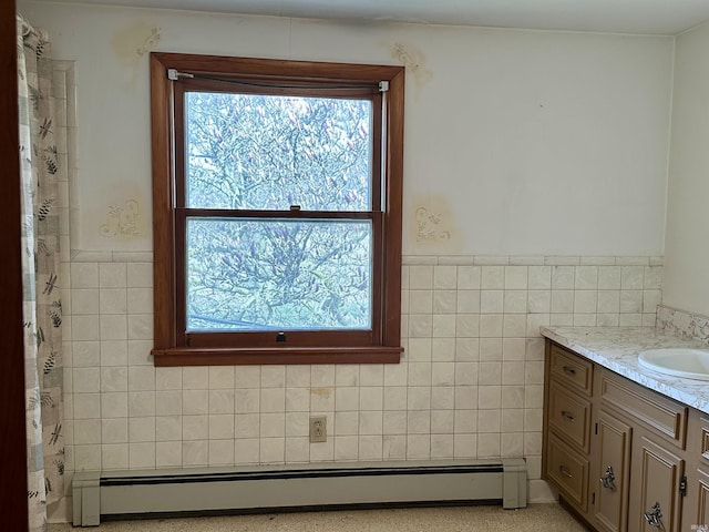 bathroom featuring a baseboard radiator, a healthy amount of sunlight, vanity, and tile walls