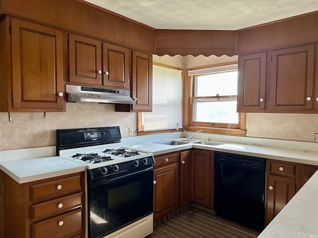 kitchen with range with gas cooktop, a sink, dishwasher, light countertops, and under cabinet range hood