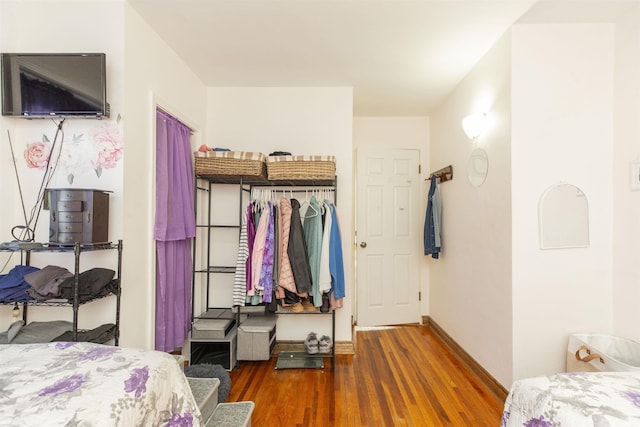 bedroom with baseboards and wood finished floors
