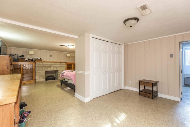 bedroom with baseboards, a fireplace, visible vents, and a closet