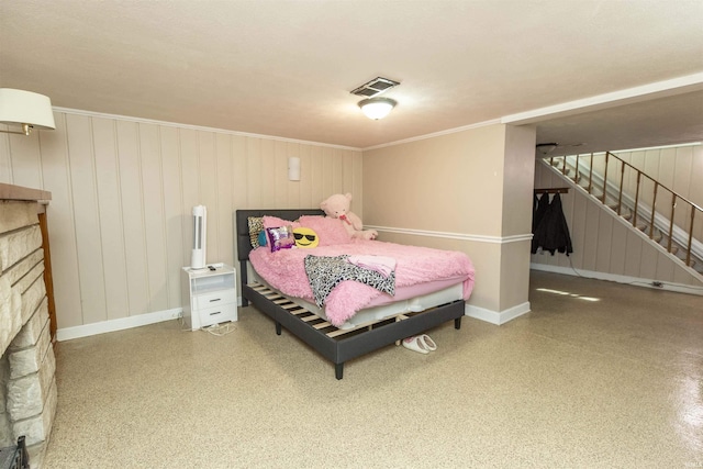 bedroom featuring speckled floor, baseboards, visible vents, and a stone fireplace