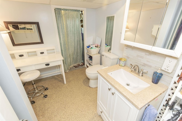 bathroom featuring toilet, backsplash, and vanity