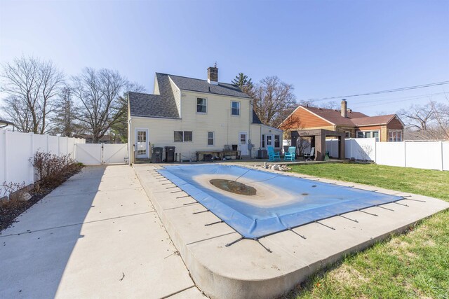 back of property featuring a fenced backyard, a lawn, a gate, and a patio area