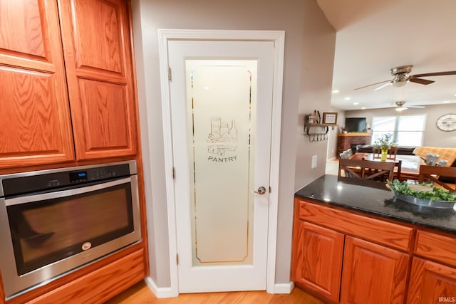 2860 E Moffett Ln, Bloomington, IN 47401 - kitchen featuring open floor plan, brown cabinetry, ceiling fan, and oven