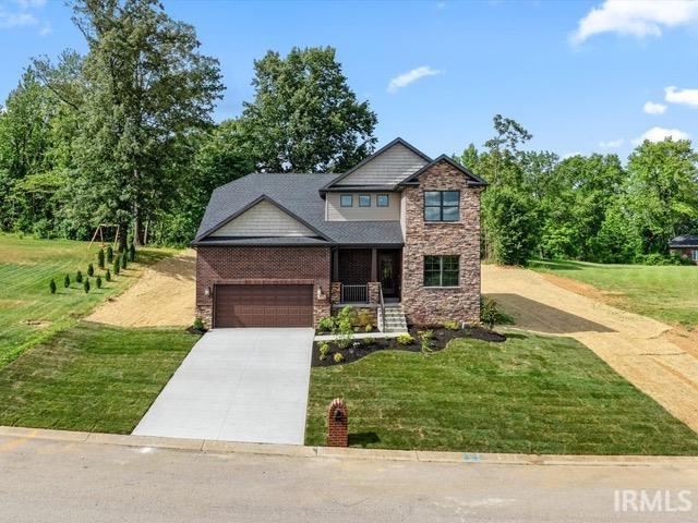 600 Whitetail Ct, Evansville, IN 47711 - craftsman-style house with stone siding, a garage, a front yard, brick siding, and driveway