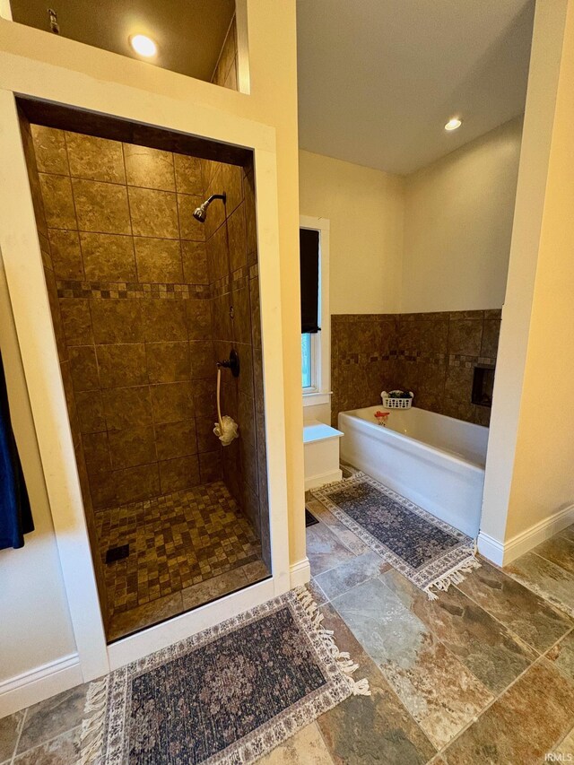 1951 Indian Mounds Blvd, Evansville, IN 47715 - bathroom featuring a shower stall, baseboards, stone finish flooring, and a bath