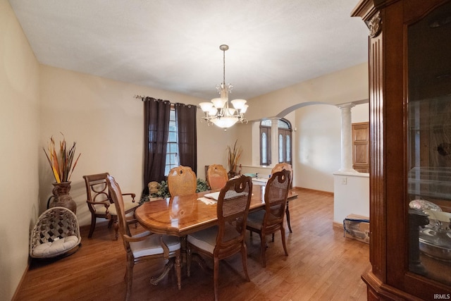 4277 S 100 W, Williamsport, IN 47993 - dining space featuring arched walkways, light wood-style flooring, a chandelier, and decorative columns