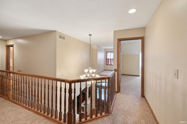 4277 S 100 W, Williamsport, IN 47993 - hallway featuring a notable chandelier, an upstairs landing, baseboards, visible vents, and carpet