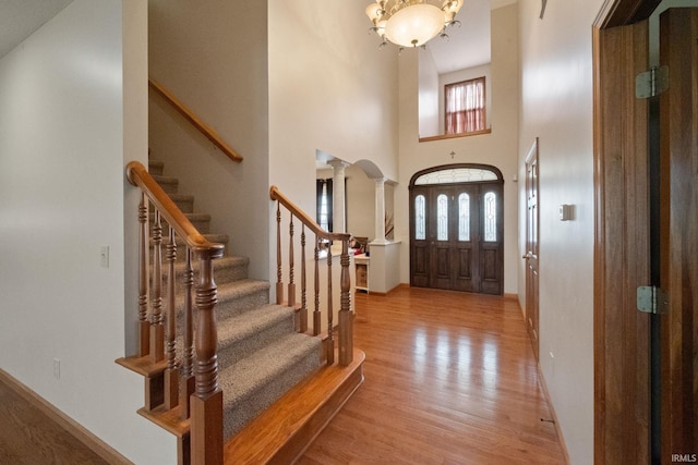 4277 S 100 W, Williamsport, IN 47993 - entrance foyer featuring decorative columns, stairway, a chandelier, baseboards, and light wood-style floors