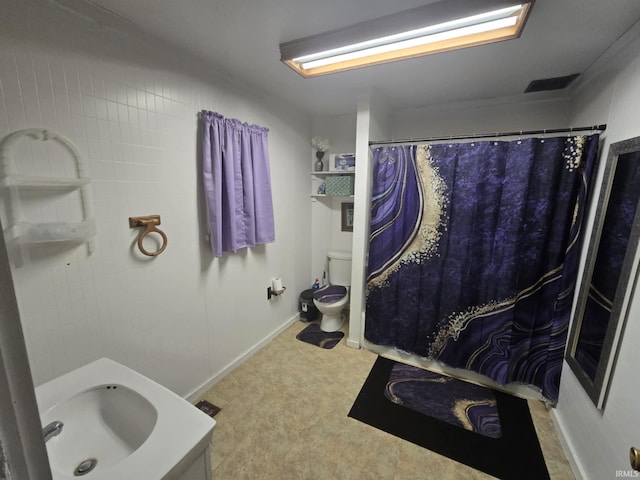 bathroom with a sink, toilet, baseboards, and curtained shower
