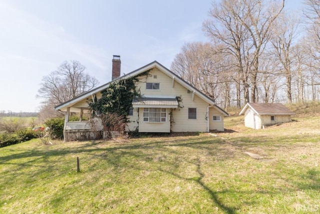 2645 S Greensboro Pike, New Castle, IN 47362 - rear view of property with a chimney, an outbuilding, a storage shed, and a yard