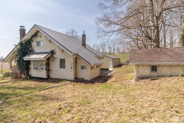 2645 S Greensboro Pike, New Castle, IN 47362 - view of side of property with a chimney, metal roof, and a yard